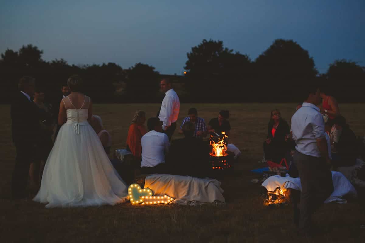 Outdoor fire pit bale seating and battery light up letters for tipi wedding