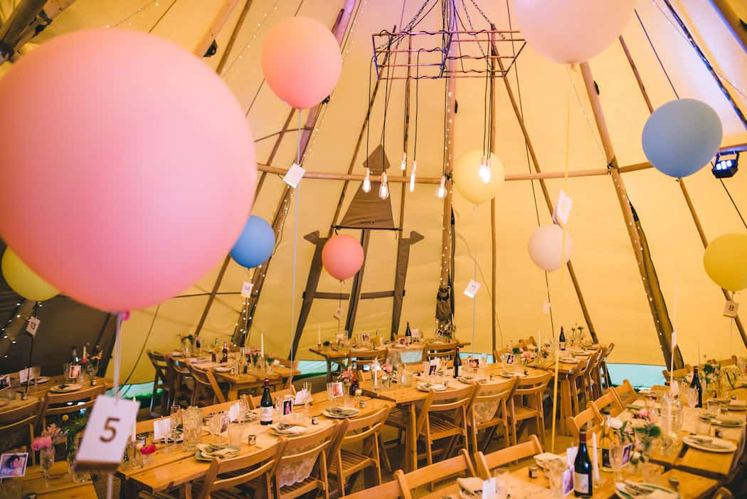 Tables, hanging light and giant balloon styling for bawdon lodge farm tipi wedding celebration
