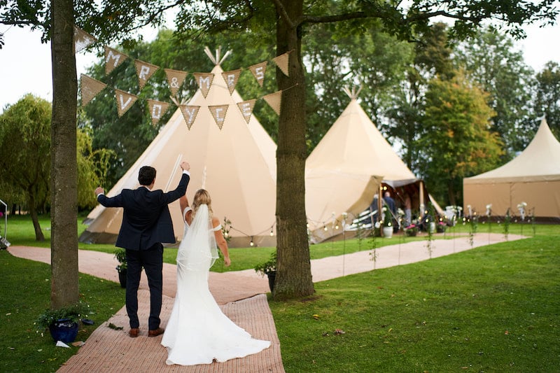 Happy couple in front of tipis
