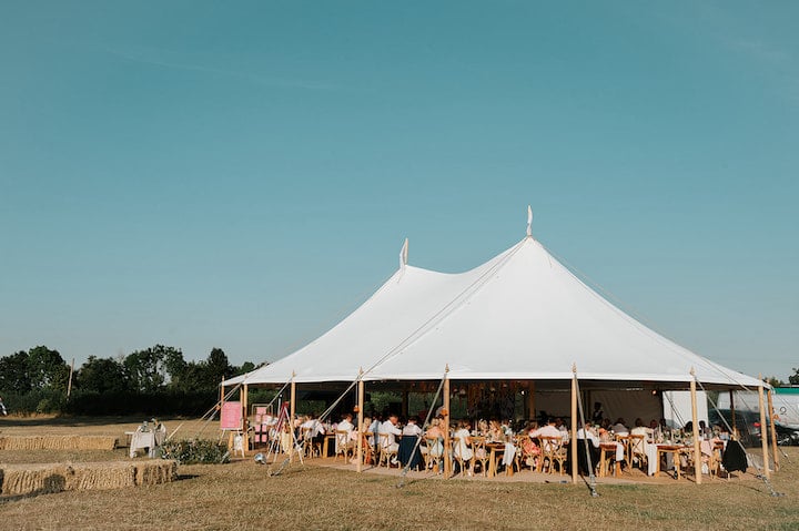9 Top Tips For Coping With Hot Weather. Two pole sailcloth with guests all seated inside. Sky is bright blue and sunny behind.