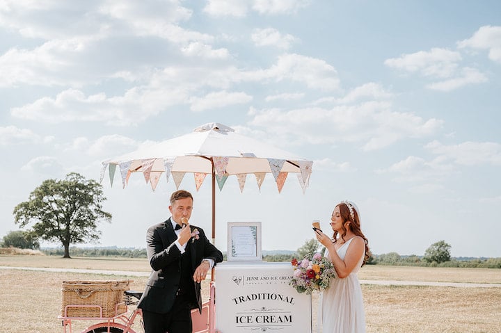 9 Top Tips For Coping With Hot Weather. Bride and groom eating ice cream stood next to the ice cream trike in the sunshine.